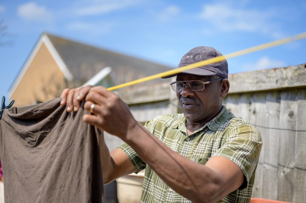 a man hanging clothes outside for sun drying